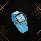 Elegance sky blue quartz watch displayed from a 45-degree angle, highlighting the textured dial depth, silver case finishing, and rubber strap on a sophisticated black and gold background.