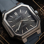 Macro closeup hero shot of the Elegance dark grey textured dial, silver hour markers, hands, and branded logo under sophisticated soft spotlighting.