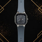 Elegance luxury men's quartz watch featuring a dark grey horizontal textured dial, polished silver octagonal case, and slate grey silicone strap, shown in a straight-on front view against a black and gold abstract background.