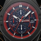 Macro close-up shot of XTRI watch dial showing chronograph subdials, red chapter ring, hour markers, and date aperture framed by luxury black and gold elements.